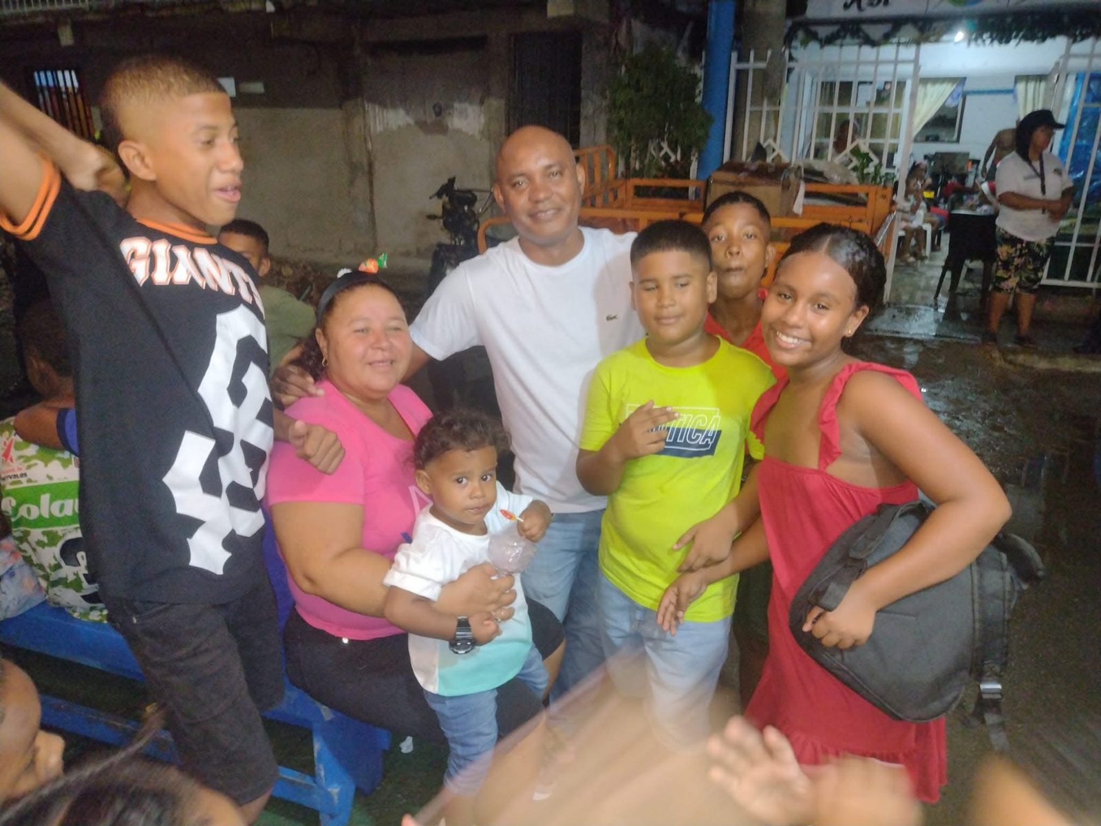 Alexis Ramírez junto a una familia del barrio durante una actividad nocturna en San Andrés.