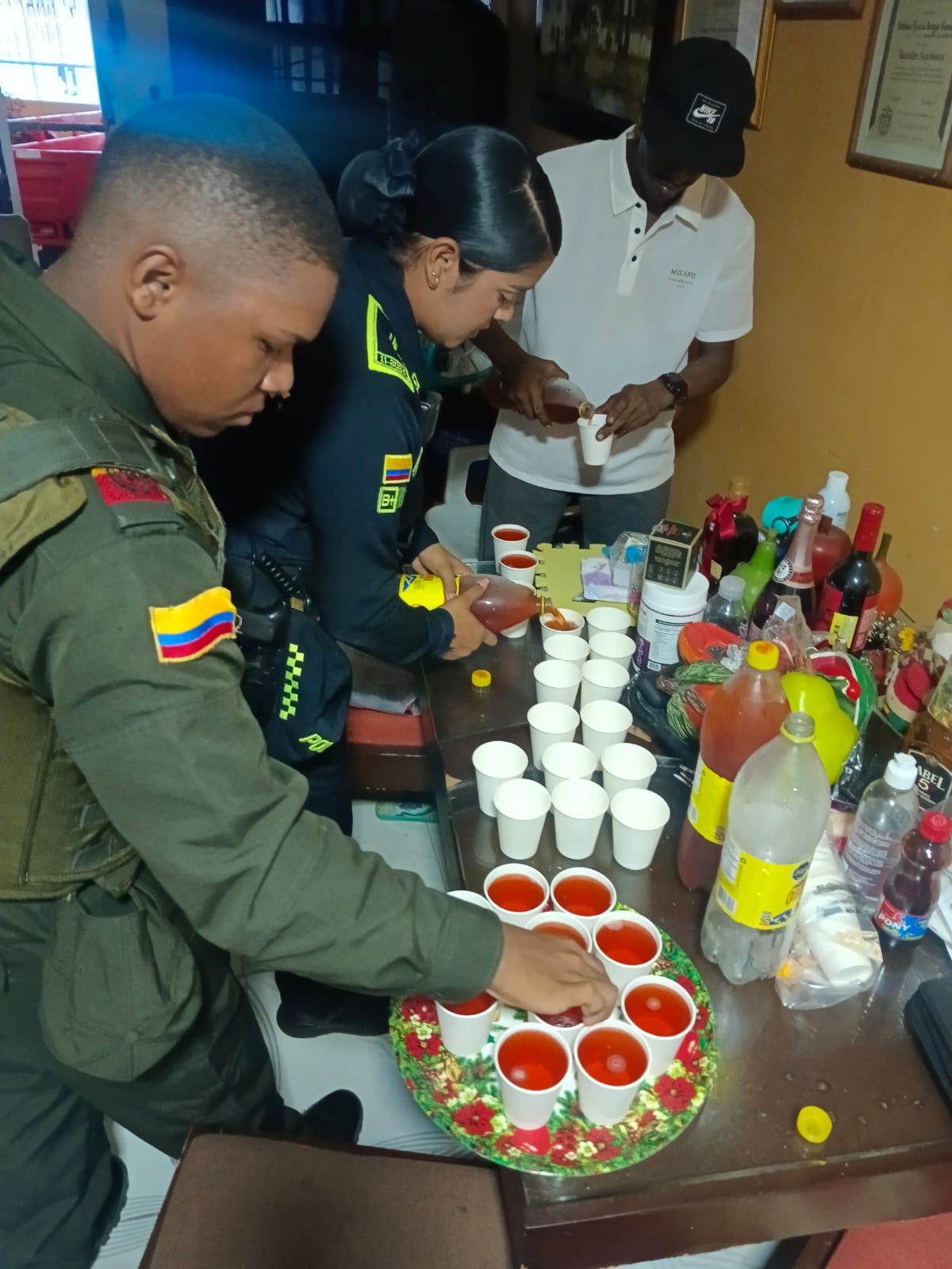 Voluntarios y policía comunitaria preparando bebidas para una actividad de Gastro Plus.