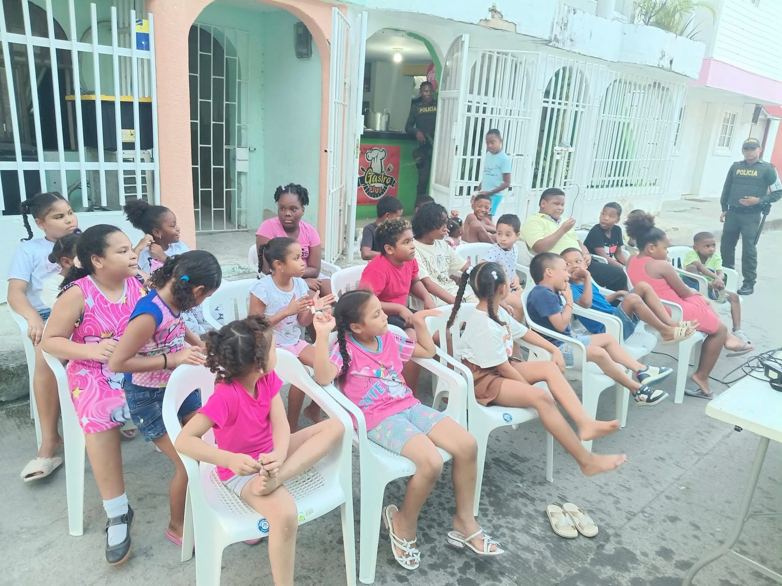Niños reunidos en una actividad comunitaria frente al local de Gastro Plus.